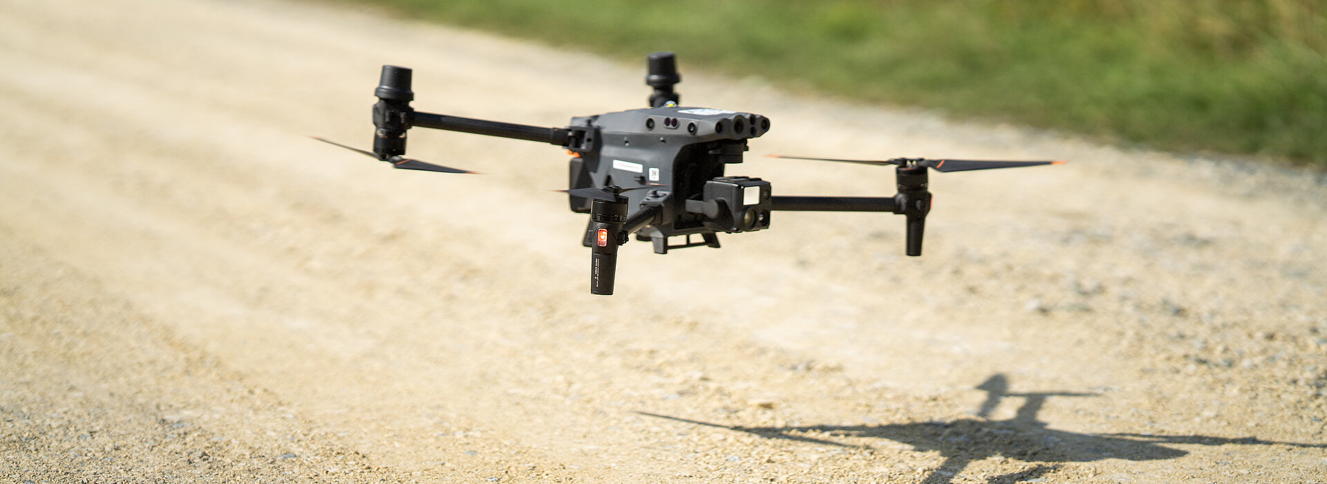Eine Drohne setzt zum Landen auf einer Schotterstraße an