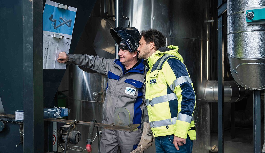 PMS Mitarbeiter beim Arbeiten an der Anlage im Heizkraftwerk inkl. Kontrolle am Plan