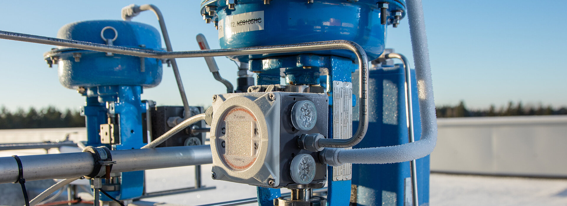 Ein blaues Ventil im Feien am Dach einer Industrieanlage