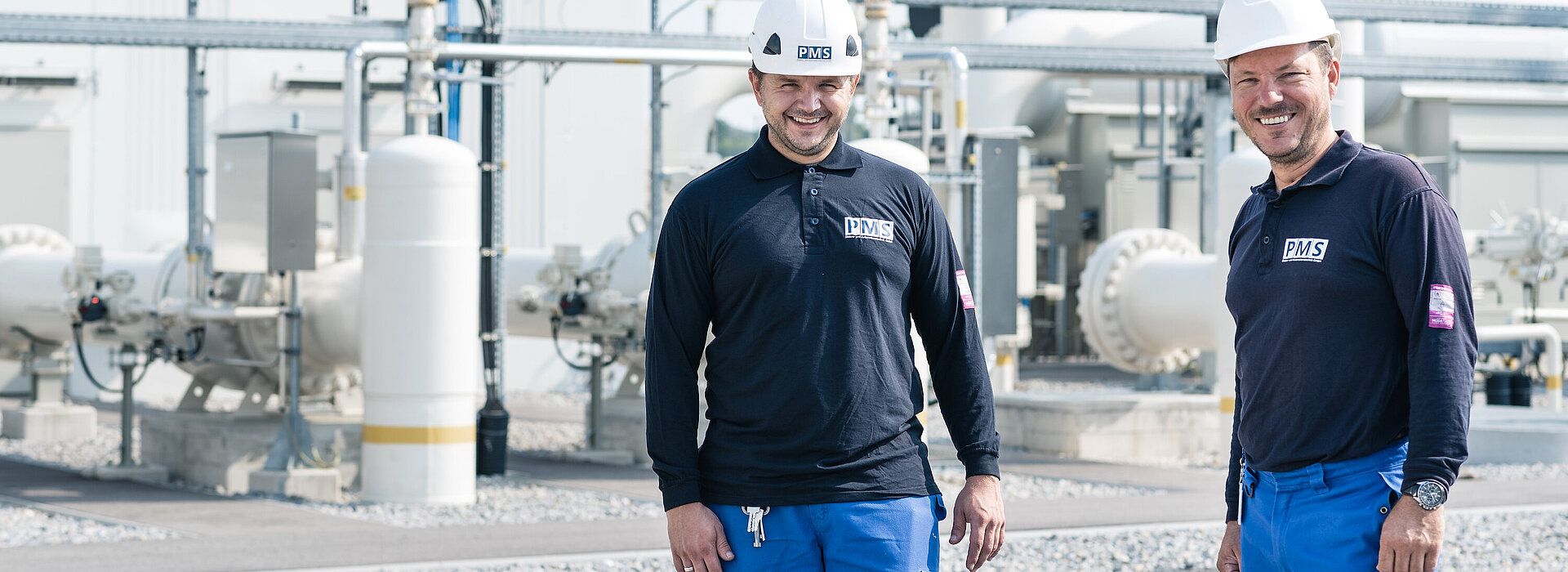 Zwei Montagemitarbeiter der PMS Elektro- und Automationstechnik, im Hintergrund eine Gasstation des Kunden