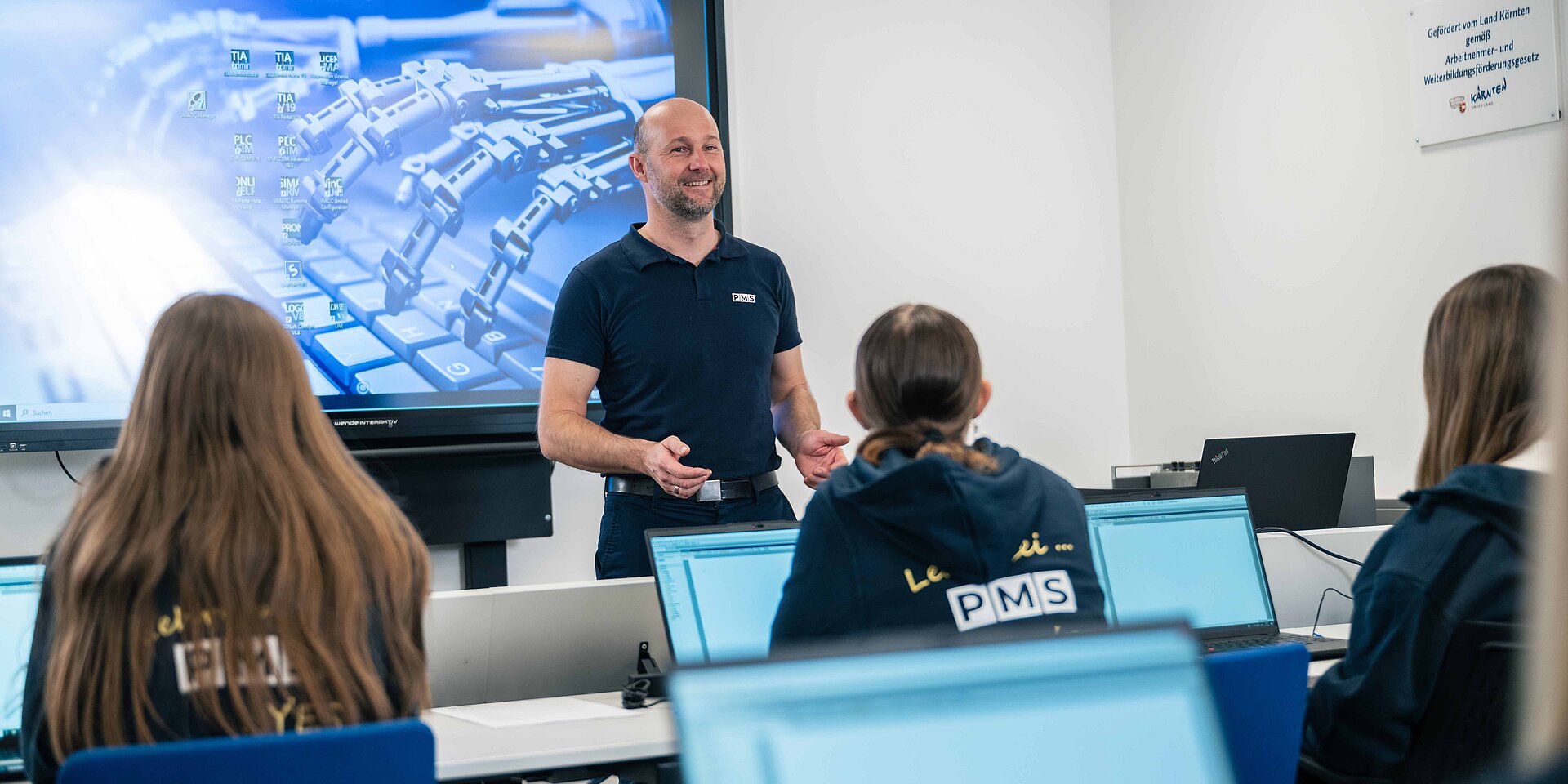 Ein Lehrlingsausbilder beim Unterricht mit Lehrlingen in der Lehrwerkstatt