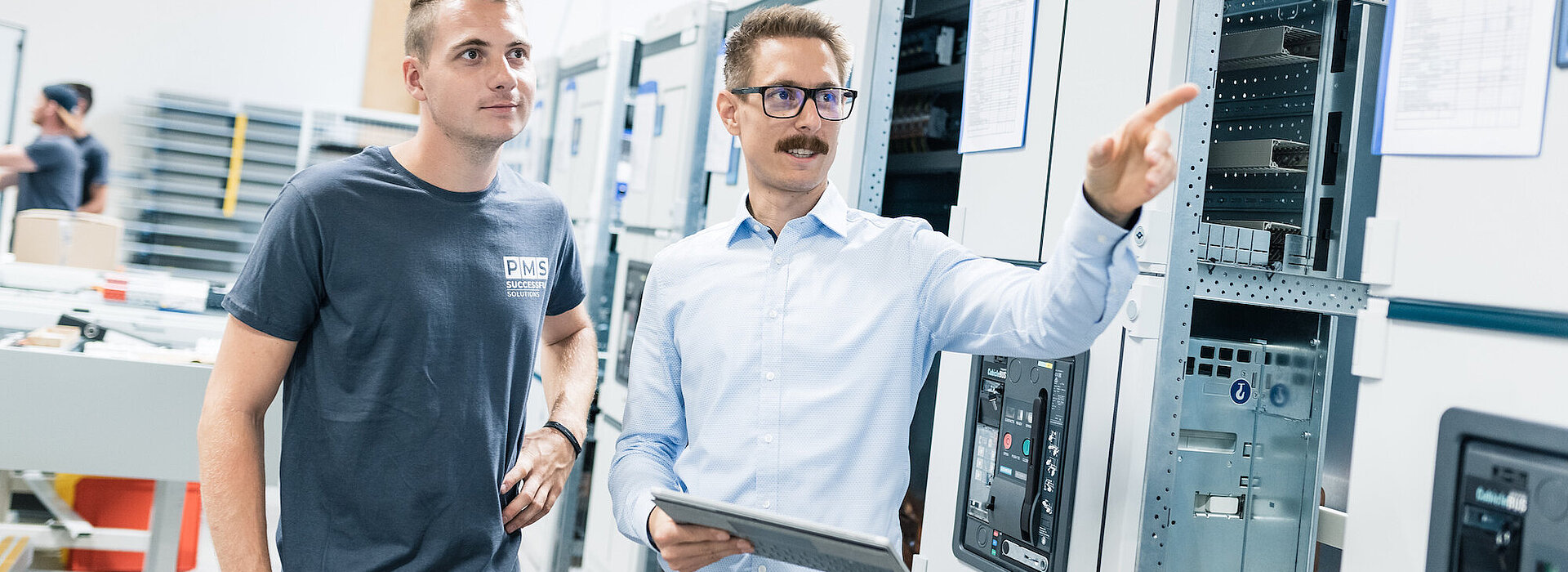 Mitarbeiter beim Überprüfen an einer Reihe von Schaltanlagen in der Fertigung