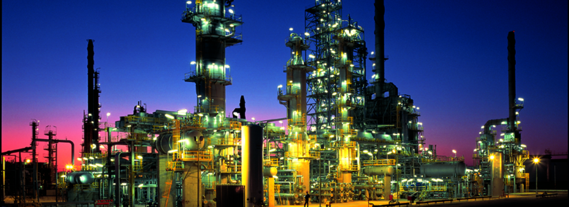 Große beleuchtete Industrieanlage vor einem Abendhimmel