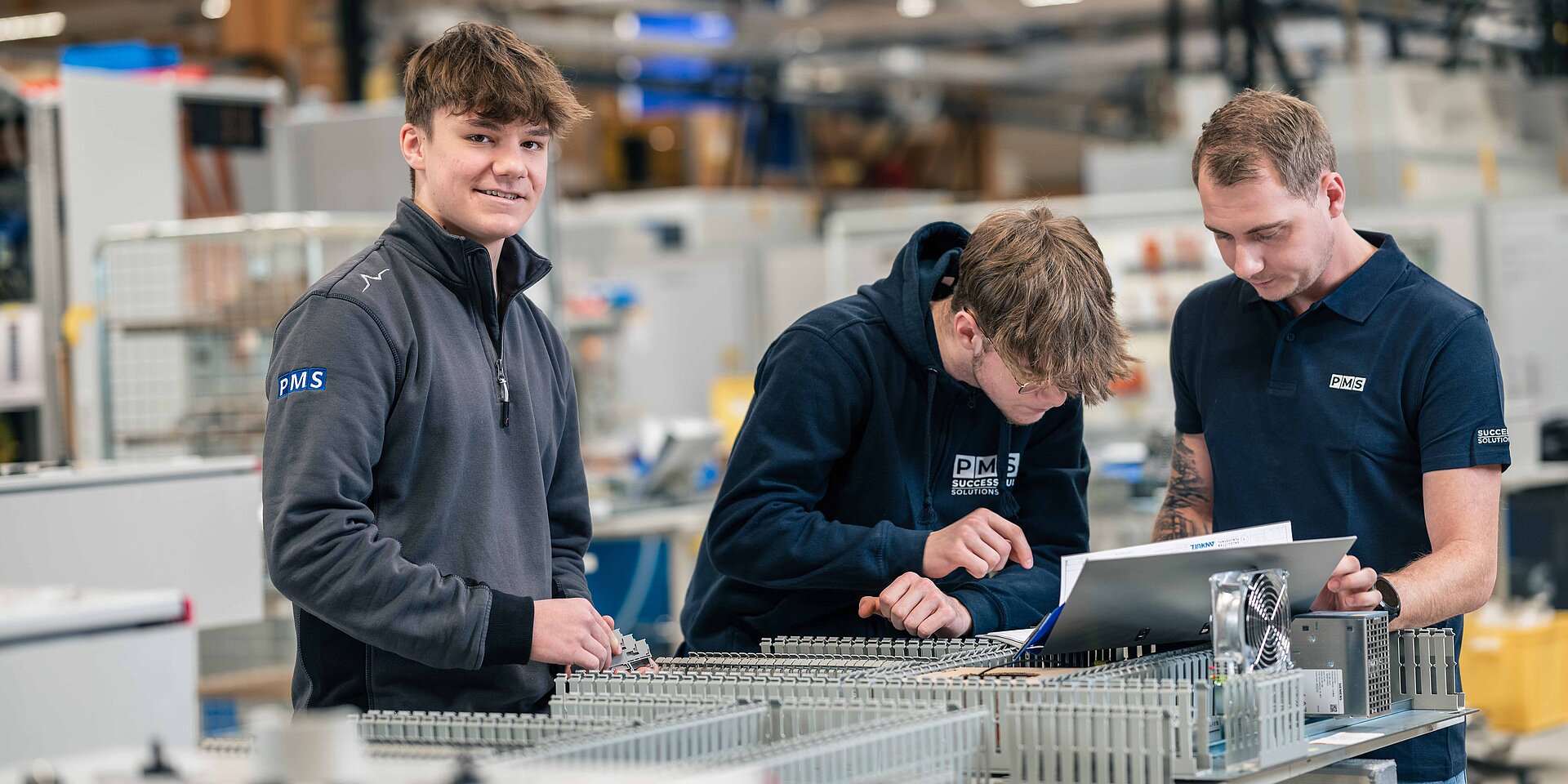 3 Lehrlinge beim Arbeiten in der Fertigung