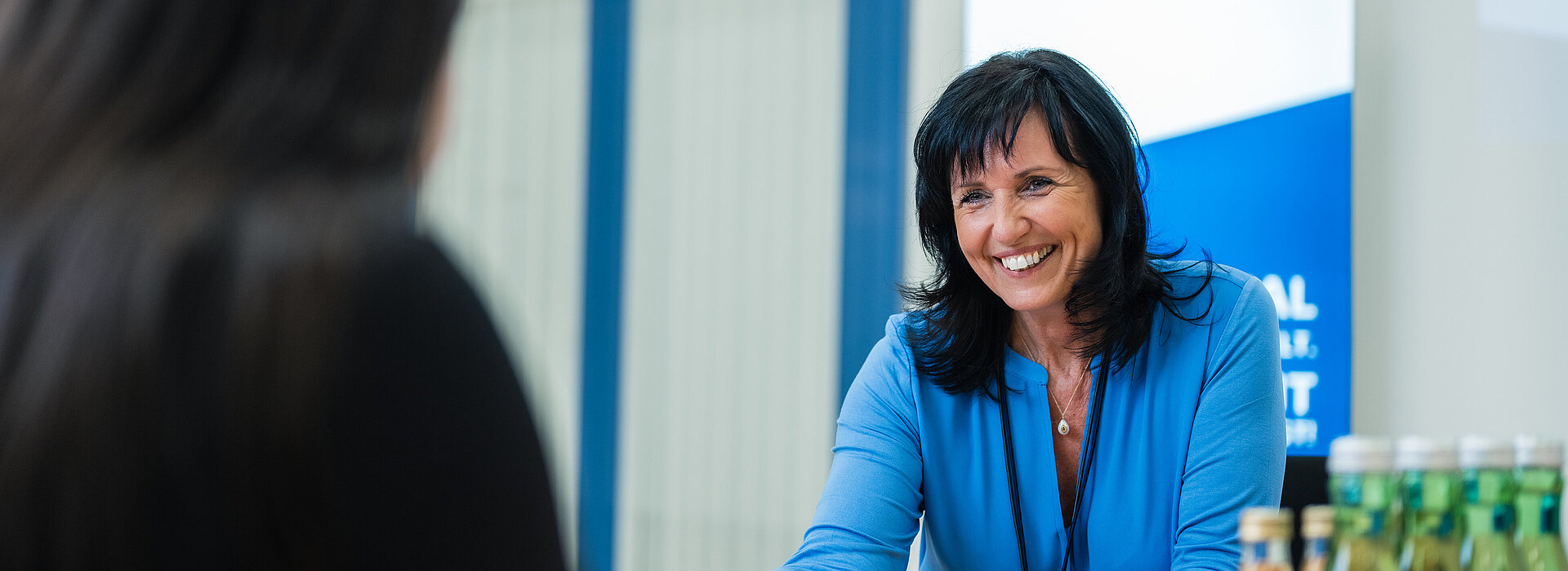 Bild von Doris Monsberger im Gespräch mit einer Mitarbeiterin.