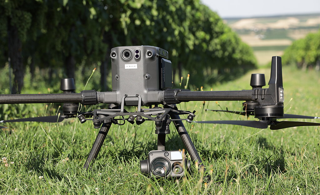 Drohne auf einer Wiese im Weingarten am Boden